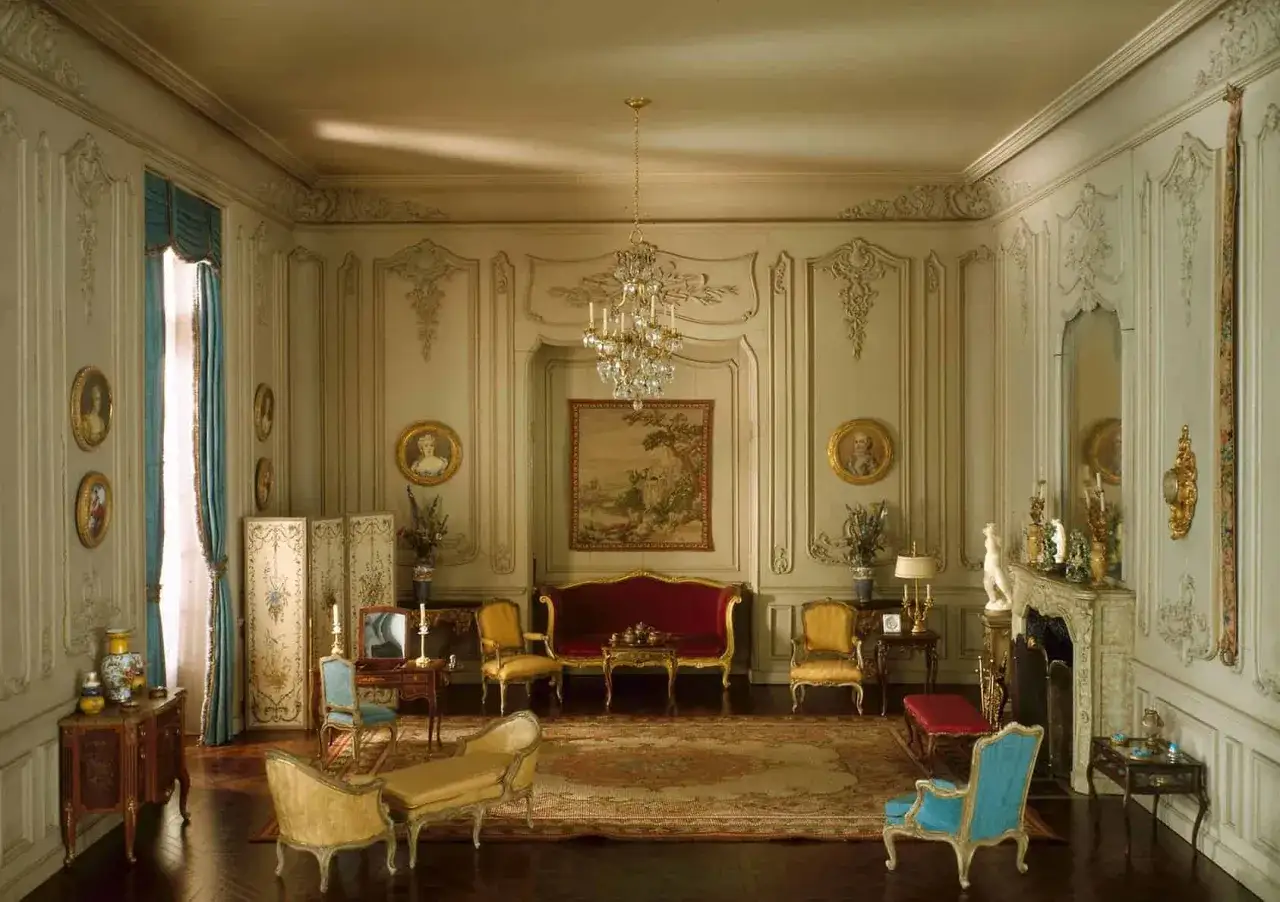 Elegancki salon w stylu Ludwika XV, z bogatymi zdobieniami, aksamitną kanapą i kryształowym żyrandolem.